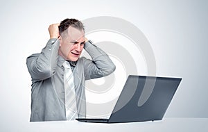Man in horror grabs his head looking at the laptop screen. Concept of computer problems