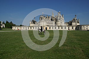 Man on a horse on the lawn near the castle of Chambord, Castles of the Loire, France