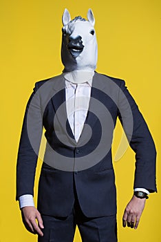 Man with horse mask on yellow background