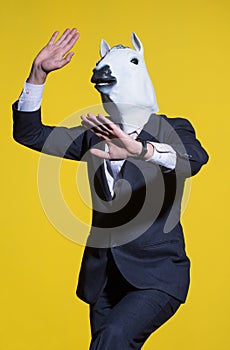 Man with horse mask on yellow background