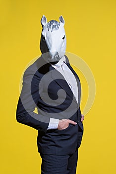 Man with horse mask on yellow background