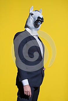 Man with horse mask on yellow background