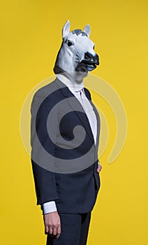 Man with horse mask on yellow background