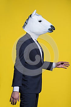 Man with horse mask on yellow background