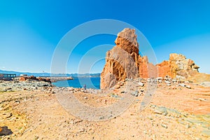 Man by a huge rock in Rocce Rosse beach