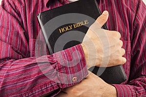 Man hugging a Bible