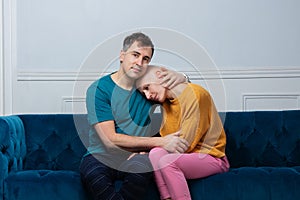 Man hugging and comforting bald woman ill of cancer sit on sofa