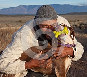 Man hugging and playing with his dog