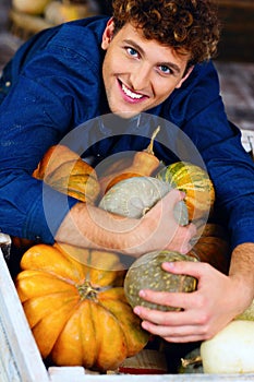 man hugging pumpkins
