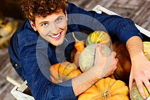 Man hugging pumpkins