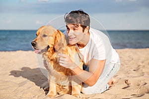 Man hugging and talking with dog on the beach