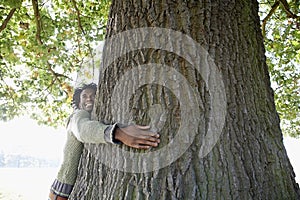 Man Hugging Tree Trunk At Park