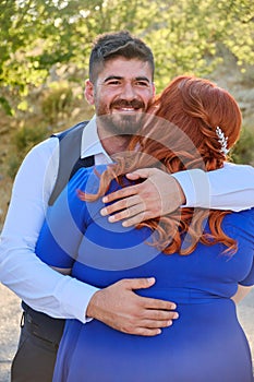 Man hugs his beloved woman smiling