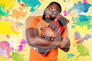 Man hugs an old stereo. he love the music. yellow background