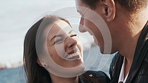 Man hugs a woman tightly and lovingly on the street on a sunny day.