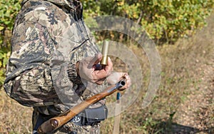 A man with a hunting rifle in his hands, loading a weapon