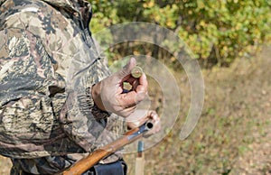 A man with a hunting rifle in his hands, loading a weapon