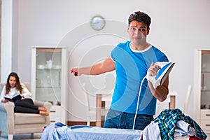 The man husband ironing at home helping his wife