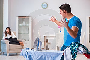 The man husband ironing at home helping his wife