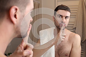 Man hushing himself in front of the mirror