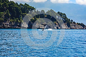 A man on a hydrocycle sails along the coast