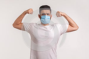 Man in hygienic mask showing strength and immunity to recover from contagious disease