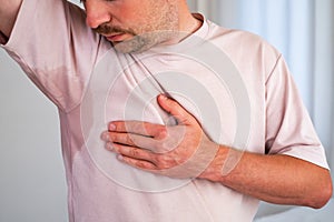 Man with hyperhidrosis sweating very badly under armpit
