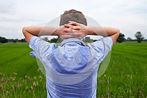 Man with hyperhidrosis sweating very badly under armpit in blue shirt, on grey