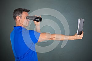 Man With Hyperopia Eye Disorder Reading A Book Using Binocular