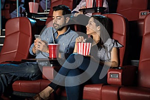 Man ignoring his date and the movie