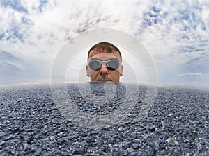 Man immersed in the middle of an ocean of asphalt water and cloudy sky