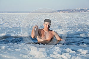Man immersing in icy water on winter day. Baptism ritual