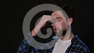 A Man Immitating Headache Against a Black Background