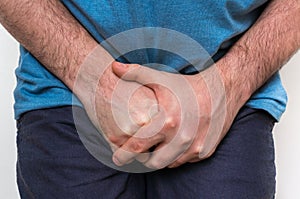 Man with incontinence problem is holding his crotch