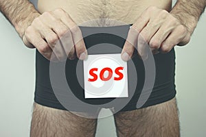 ..Man with incontinence problem holding paper with SOS