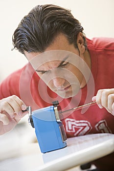 Man indoors using pencil sharpener