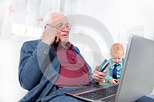 Man indoors using telephone and looking at credit card