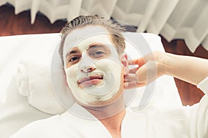 Man indulges in rejuvenating with luxurious face cream spa massage. Quiescent