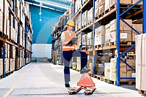 Man in industrial warehouse checking list