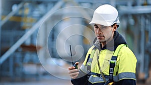 Man industrial worker walkie talkie communication at refinery manufacture plant closeup