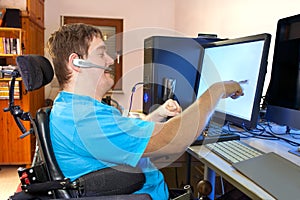 Man with infantile cerebral palsy using a computer. photo