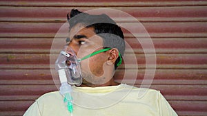 Man infected with Covid 19 disease. Patient inhaling oxygen wearing mask with liquid Oxygen flow