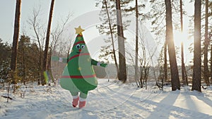 A man in an inflatable doll costume Christmas tree runs to hug