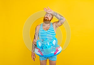 man with inflatable donut with elephant is ready to swim