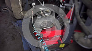 Man inflate tire air on mounting machine.