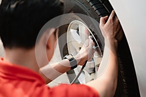 A man is inflating a tire with a tire inflator