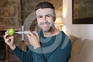 Man injecting liquid inside apple