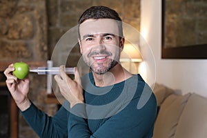 Man injecting liquid inside apple