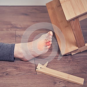 Man injured foot after falling from wooden stepladder. Ladder made of wood broke under a man while working at home