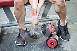 Man injury Wrist pain after workout with dumbbell in gym